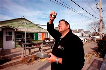 (AP Photo/Mark Lennihan). In this photo of Tuesday, Nov. 20, 2012, Paul Ciccarello views a Kodachrome slide outside his home in the oceanside community of Breezy Point in New York.