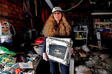 (AP Photo/Kathy Willens). In this photo taken Nov. 19, 2012, Roseanne Schnoll holds her parents' wedding album, a keepsake item she recovered from workers were cleaning out her flooded basement and garage in the Belle Harbor neighborhood New York.